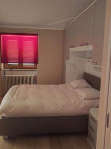 a bedroom with a bed with a red window at La tana della Fenice in Labico +4 photos