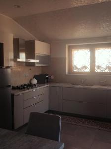 a kitchen with white cabinets and a sink and a window at La tana della Fenice in Labico