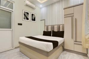 a bedroom with a bed in a room at Super Hotel O Maharshi Valmiki International Airport Formerly Gaurav Inn in Faizābād +23 photos