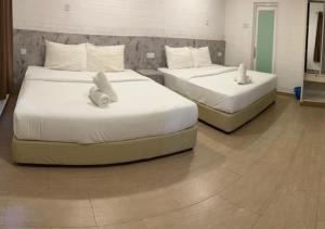 two beds with stuffed animals on them in a room at D'Lima Beach Inn in Pantai Cenang +84 photos