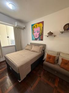 ein Schlafzimmer mit einem Bett und einer Couch in der Unterkunft Estúdio 9º andar em frente à Praça da República in Belém