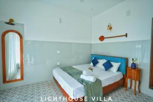 a bedroom with a bed with a mirror and a table at Lighthouse Villa in Cherai Beach