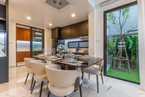 a dining room with a long table and chairs at Southern Peak Pool Villa Huay Yai Pattaya in Ban Huai Yai
