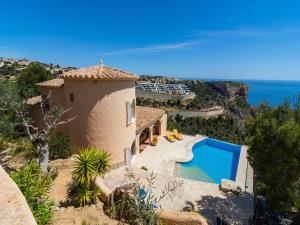 a house with a swimming pool next to the ocean at Villa with Sea Breeze Charm in Cumbre del Sol