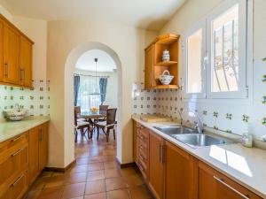 cocina con fregadero y mesa en Villa with Sea Breeze Charm, en Cumbre del Sol