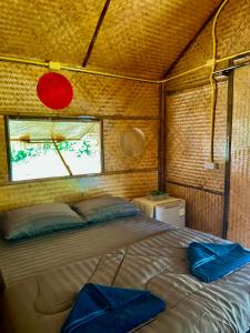 a bed in a small room with a window at Bunga Hut Koh Lanta 