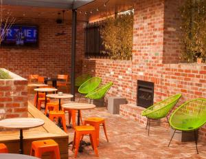 a patio with tables and chairs and a fireplace at Western Hotel Ballarat in Ballarat