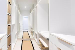 ein begehbarer Kleiderschrank mit weißen Schränken und goldenen Akzenten in der Unterkunft Secluded Serene in Saint Philip + 14 Fotos
