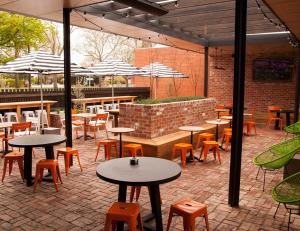 un patio al aire libre con mesas, sillas y sombrillas en Western Hotel Ballarat, en Ballarat