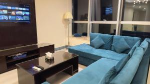 イスラマバードにあるWalk-Inn Hospitality Group Centaurusの青いソファとテレビのあるリビングルーム