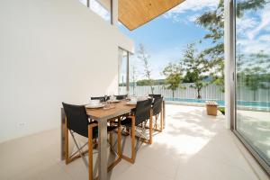 a dining room with a table and chairs at The Trinity C4 new modern 5BR villa with 20M Pool in Ban Pak Lak