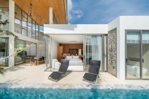 a villa with a swimming pool and a bedroom at The Trinity C4 new modern 5BR villa with 20M Pool in Ban Pak Lak
