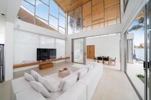 a living room with white furniture and large windows at The Trinity C4 new modern 5BR villa with 20M Pool in Ban Pak Lak