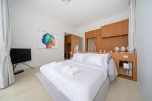a bedroom with a large white bed and a television at The Trinity C4 new modern 5BR villa with 20M Pool in Ban Pak Lak +15 photos