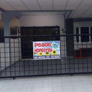 a sign on a fence in front of a house at Peace Homestay in Simpang