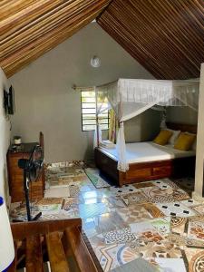 a bedroom with a bunk bed and a room with a floor at Le Jardin Arhumatic Sambava in Sambava