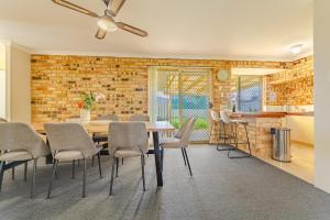 una sala da pranzo con tavolo e sedie e un muro di mattoni di StayAU 4BR Family Retreat with Garden Near Perth a Westfield
