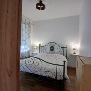 a bedroom with a black bed with a white comforter at Trekker's Home L'infinito & SPA in Pessinetto