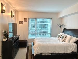 - une chambre avec un lit, une commode et une fenêtre dans l'établissement Channelside Luxury Retreat Spacious 2BR 2BA Condo with Pool, Balcony, Sauna & Gym, à Tampa