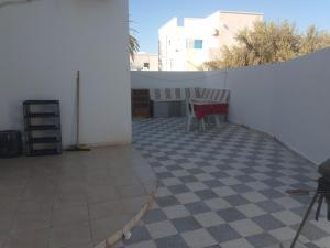a room with a white wall and a tiled floor at Christiana 1 in Midoun