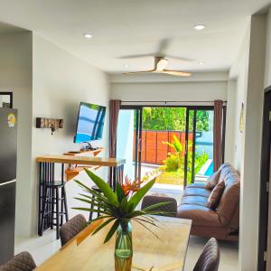 ein Wohnzimmer mit Tisch und Couch in der Unterkunft Villa Kokini in Koh Samui