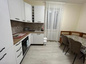 een keuken met witte kasten en een eettafel bij La Casa di MBAPE in Meda