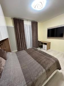 een slaapkamer met een groot bed en een flatscreen-tv bij La Casa di MBAPE in Meda
