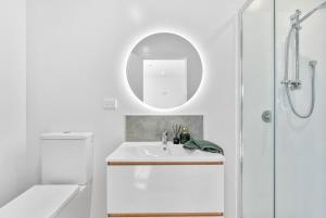 a white bathroom with a sink and a mirror at Twin Room at Wolfe Street in Whangarei +8 photos