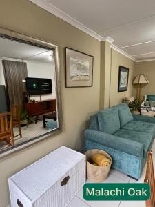 a living room with a blue couch and a mirror at AtTheDeck in Pietermaritzburg +55 photos