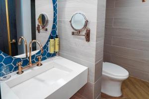 ein Badezimmer mit einem weißen Waschbecken und einer Toilette in der Unterkunft Faranda Collection Cali, a member of Radisson Individuals in Cali