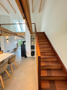 an office with a staircase and a table and chairs at Westertilli Middelhuus - modernes, luxuriöses Wohngefühl in Pellworm +9 photos