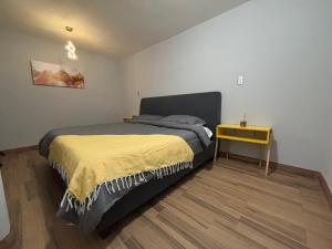 a bedroom with a bed and a yellow table at Estancia Dorada in San Pedro Atzompa