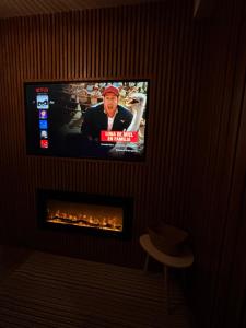 a television on a wall with a fire place at Estancia Dorada in San Pedro Atzompa