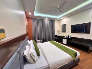 a hotel room with a bed and a television at Amber Inn by Orion Hotels in New Delhi