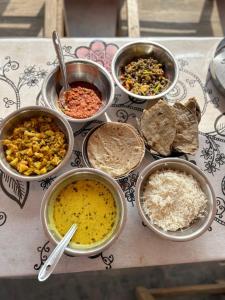 a table topped with bowls of different types of food at Gangaram osian village home stay in Osiān