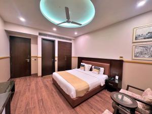 a bedroom with a bed and a ceiling fan at Amber Inn by Orion Hotels in New Delhi +61 photos