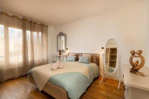 a bedroom with a bed and a large window at Maison spacieuse & calme à 9 min de la Cité in Carcassonne