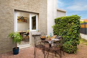 a patio with a table and chairs next to a building at Maison spacieuse & calme à 9 min de la Cité in Carcassonne