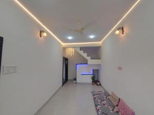 戈尔哈布尔Todkars Villa的走廊设有白色的墙壁和带灯的天花板