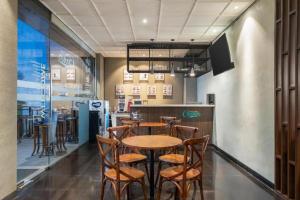 una mesa y sillas en un restaurante con bar en Indies Style Hotel Bandung, en Bandung