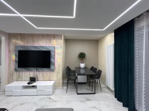 een woonkamer met een tafel en een televisie aan de muur bij La Casa di MBAPE in Meda +6 foto's