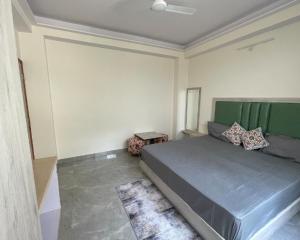 a bedroom with a large bed with a green headboard at The Refuge Inn in Lakhwār