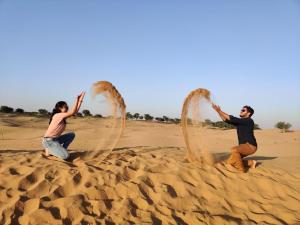 two people playing in the sand in the desert at Gangaram osian village home stay in Osiān +5 photos
