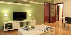 a living room with a television on a white entertainment center at Alguera Apartments Napols in Barcelona