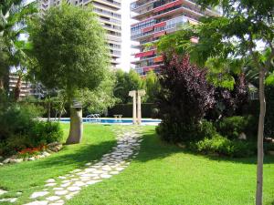 a garden with a walkway and a cross in the grass at Apartamentos Concorde in Alicante
