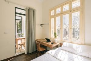 a bedroom with a bed and a desk with a laptop at The Jade Phoenix Hanoi-Cozy Retreat with Private Balcony-Free Laundry in Hanoi