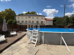 a ladder sitting next to a swimming pool at Auberge de Lamagistere in Lamagistère