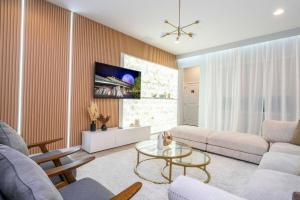 una sala de estar con un sofá y una mesa en Luxury 12BR Home w Pool Theater Game Room, en Kissimmee