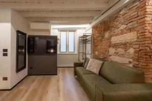 a living room with a couch and a brick wall at Stelle di Verona - Polaris in Verona