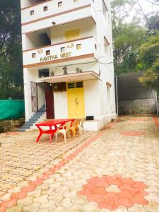 um prédio com uma mesa de piquenique vermelha na frente em Kavitha nest em Yercaud